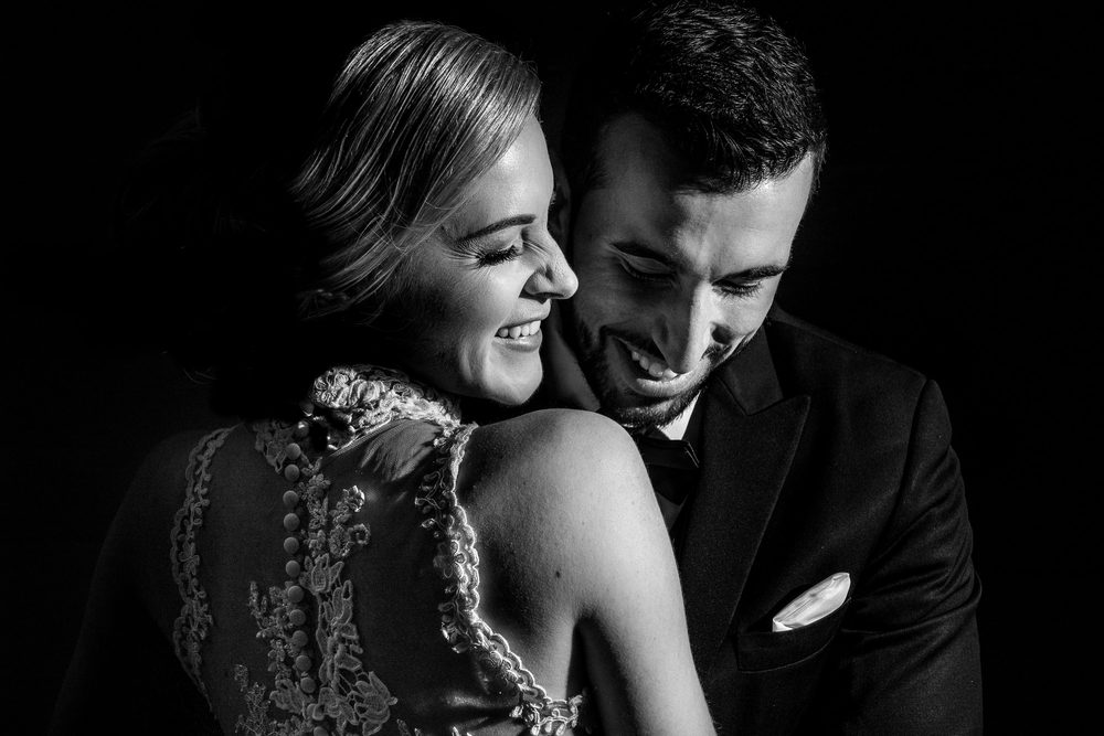 Black-and-white wedding portrait of a smiling bride and groom in downtown San Francisco